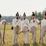 Group of men in Napoleonic uniforms posing outdoors in a historical reenactment.